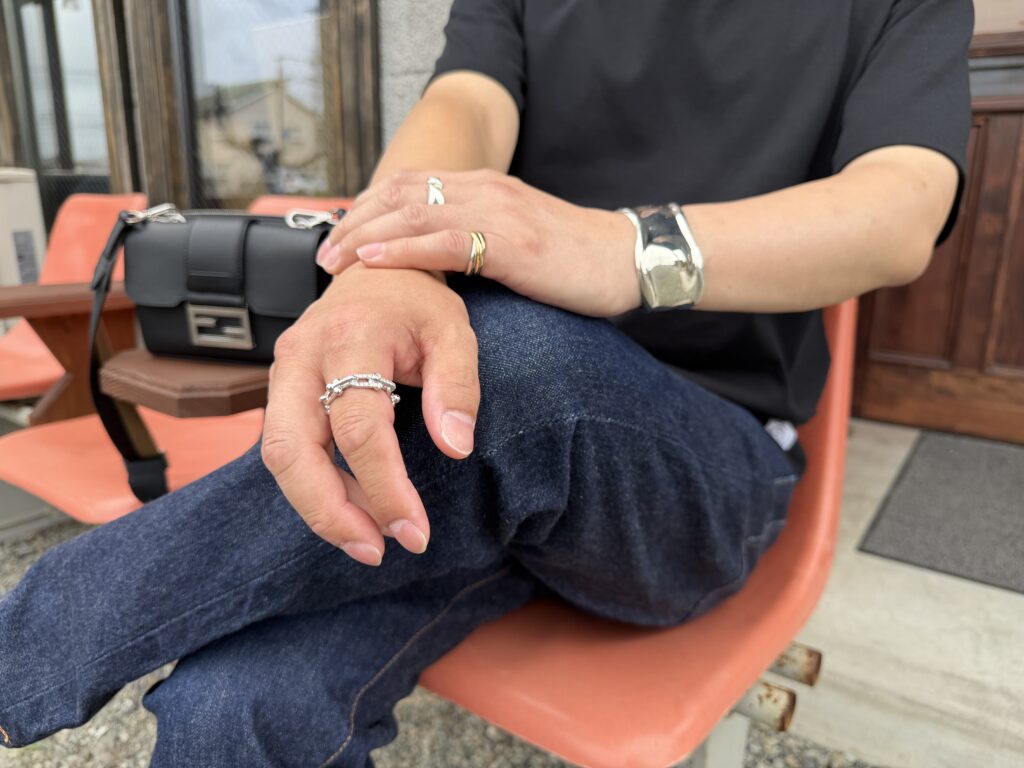 時計を着けずTiffany & Co.のバングルとCartierのリングを合わせた男性の手元